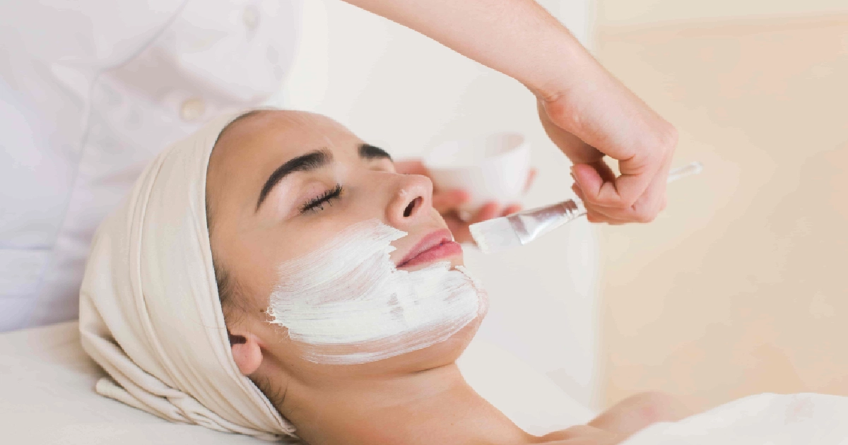A woman relaxes with eyes closed as a professional applies a white mask during a Custom Facial in Las Vegas, NV.