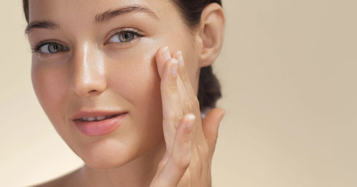 A woman with glowing, clear skin showing the confidence boost of an Ultimate Rejuvenation Facial.