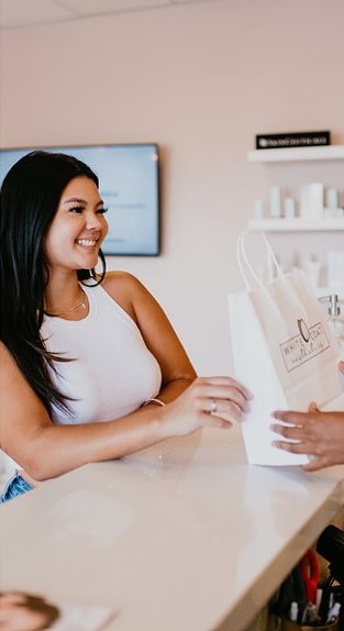 Happy woman checkout at Med Spa | White Coat Aesthetics in Las Vegas, NV